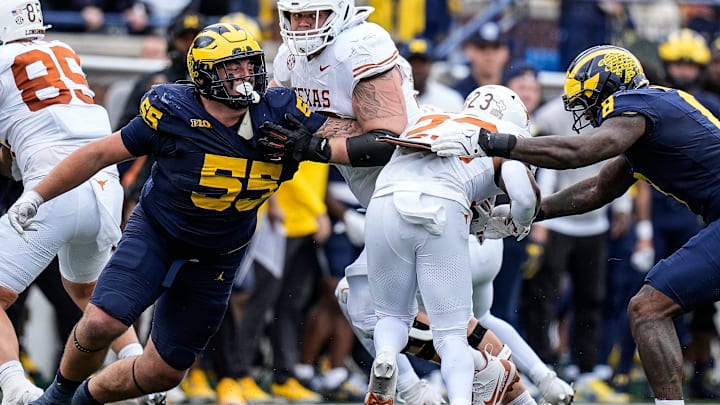 Michigan defensive lineman Mason Graham (55) and defensive end Derrick Moore (8) tackle Texas running back Jaydon Blue (23) during the second half at Michigan Stadium in Ann Arbor on Saturday, September 7, 2024.