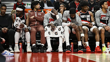 Mar 11, 2024; Portland, Oregon, USA; The Portland Trail Blazers bench, from left, guard Malcolm Brogdon (11), guard Shaedon Sharpe (17), center Duop Reath (26), center Deandre Ayton (2), guard Scoot Henderson (00), and guard Anfernee Simons (1) watch the final minutes of a game against the Boston Celtics at Moda Center. Mandatory Credit: Troy Wayrynen-USA TODAY Sports
