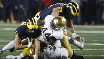 Oct 26, 2019; Ann Arbor, MI, USA; Michigan Wolverines running back Tru Wilson (13) is tackled by Notre Dame Fighting Irish defensive lineman Jamir Jones (44) and defensive back DJ Brown (12) in the second half at Michigan Stadium. Mandatory Credit: Rick Osentoski-USA TODAY Sports