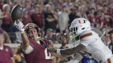 Oct 4, 2025; Tallahassee, Florida, USA; Florida State Seminoles wide receiver Duce Robinson reaches for a ball against Miami Hurricanes cornerback Xavier Lucas (6) during the first half at Doak S. Campbell Stadium. Mandatory Credit: Melina Myers-Imagn Images