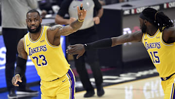 Jan 25, 2021; Cleveland, Ohio, USA; Los Angeles Lakers forward LeBron James (23) celebrates his three-point basket with center Montrezl Harrell (15) in the first quarter against the Cleveland Cavaliers at Rocket Mortgage FieldHouse. Mandatory Credit: David Richard-Imagn Images