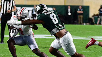 Sep 28, 2024; East Lansing, Michigan, USA;  Michigan State Spartans defensive lineman Anthony Jones (8) tackles Ohio State Buckeyes wide receiver Jeremiah Smith (4) in the first quarter at Spartan Stadium. Mandatory Credit: Dale Young-Imagn Images