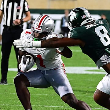 Sep 28, 2024; East Lansing, Michigan, USA;  Michigan State Spartans defensive lineman Anthony Jones (8) tackles Ohio State Buckeyes wide receiver Jeremiah Smith (4) in the first quarter at Spartan Stadium. Mandatory Credit: Dale Young-Imagn Images