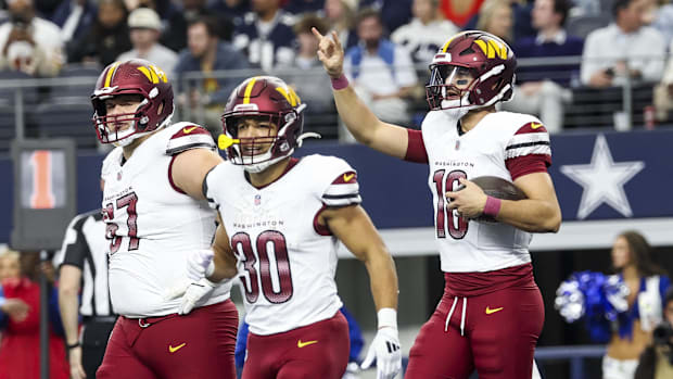 Jan 5, 2025; Arlington, Texas, USA;  Washington Commanders quarterback Marcus Mariota (18) celebrates with teammates after sc