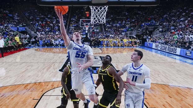 Creighton Bluejays guard Baylor Scheierman (55) shoots a layup against Oregon Ducks center N'Faly Dante (1) .