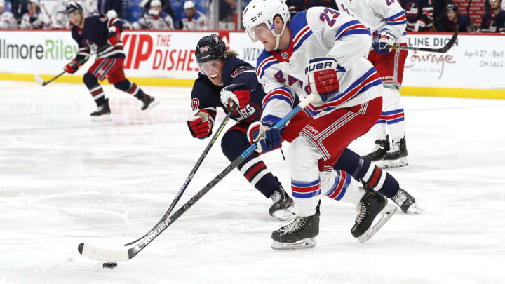 Feb 11, 2020; Winnipeg, Manitoba, CAN;  Winnipeg Jets right wing Patrik Laine (29) checks New York Rangers defenseman Adam Fox (23) in the second period at Bell MTS Place. Mandatory Credit: James Carey Lauder-USA TODAY Sports