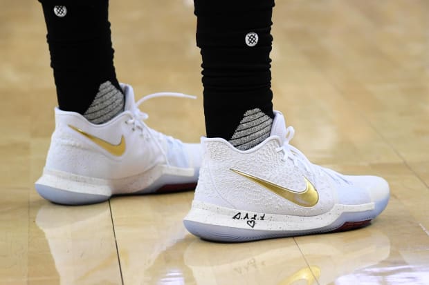 Kyrie Irving's white and gold Nike sneakers.