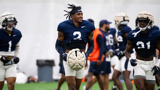 Penn State's KJ Winston runs while holding his helmet in his hands during a Nittany Lions football practice.