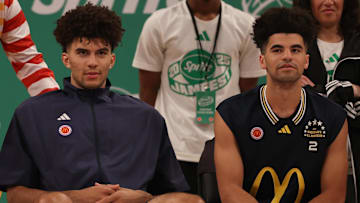 Mar 31, 2025; Brooklyn, New York, USA; McDonald’s All Americans East forward Cameron Boozer (12), left, and East guard Cayden Boozer (2), right, sit on the court during the Sprite Jam Fest at Barclay's Center. Mandatory Credit: Pamela Smith-Imagn Images