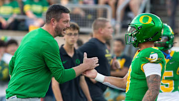 Oregon coach Dan Lanning celebrates with quarterback Dillon Gabriel during warmups before the game against Boise State at Autzen in Eugene Sept. 7, 2024.