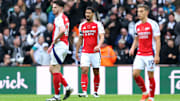 Declan Rice, William Saliba and Leandro Trossard look on after Newcastle's goal