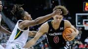 Mar 14, 2024; Kansas City, MO, USA; Cincinnati Bearcats guard Dan Skillings Jr. (0) drives past Baylor Bears guard Jayden Nunn (2) during the second half at T-Mobile Center. Mandatory Credit: William Purnell-Imagn Images