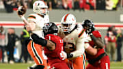 Nov 4, 2023; Raleigh, North Carolina, USA; Miami Hurricanes quarterback Tyler Van Dyke (9) throws a pass as he is pressured by North Carolina State Wolfpack defensive end Davin Vann (1) during the second half at Carter-Finley Stadium.  Mandatory Credit: Rob Kinnan-Imagn Images