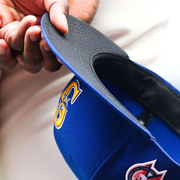 A member of the Seattle Mariners holds a baseball hat with a patch honoring the victims of the September 11th terrorist attacks before the game against the Atlanta Braves at T-Mobile Park in 2022.