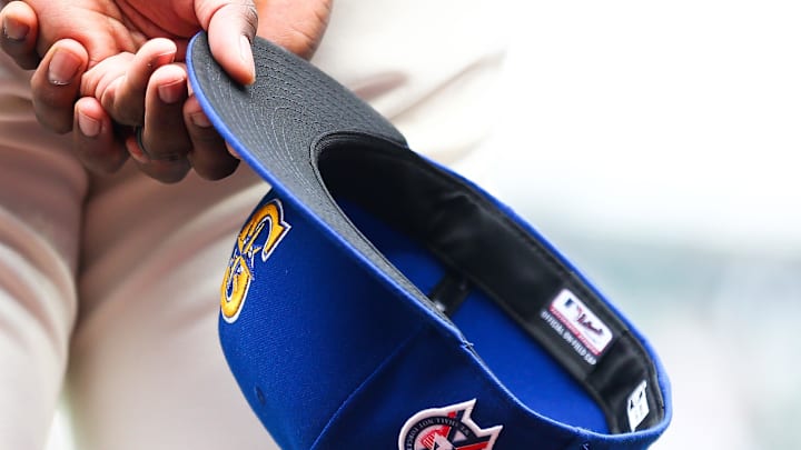 A member of the Seattle Mariners holds a baseball hat with a patch honoring the victims of the September 11th terrorist attacks before the game against the Atlanta Braves at T-Mobile Park in 2022.