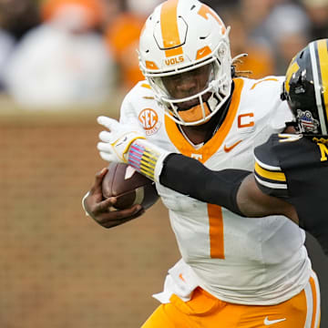 Nov 11, 2023; Columbia, Missouri, USA; Tennessee Volunteers quarterback Joe Milton III (7) stiff arms Missouri Tigers linebacker Triston Newson (14) during the first half at Faurot Field at Memorial Stadium. Mandatory Credit: Jay Biggerstaff-Imagn Images