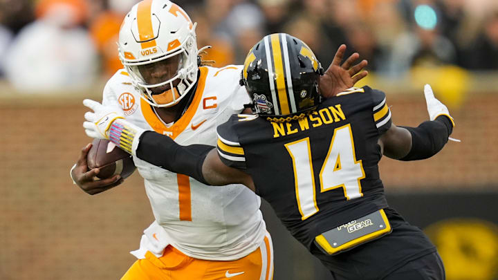 Nov 11, 2023; Columbia, Missouri, USA; Tennessee Volunteers quarterback Joe Milton III (7) stiff arms Missouri Tigers linebacker Triston Newson (14) during the first half at Faurot Field at Memorial Stadium. Mandatory Credit: Jay Biggerstaff-Imagn Images