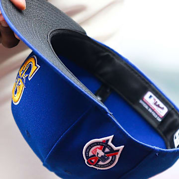 A member of the Seattle Mariners holds a baseball hat with a patch honoring the victims of the September 11th terrorist attacks before the game against the Atlanta Braves at T-Mobile Park in 2022.