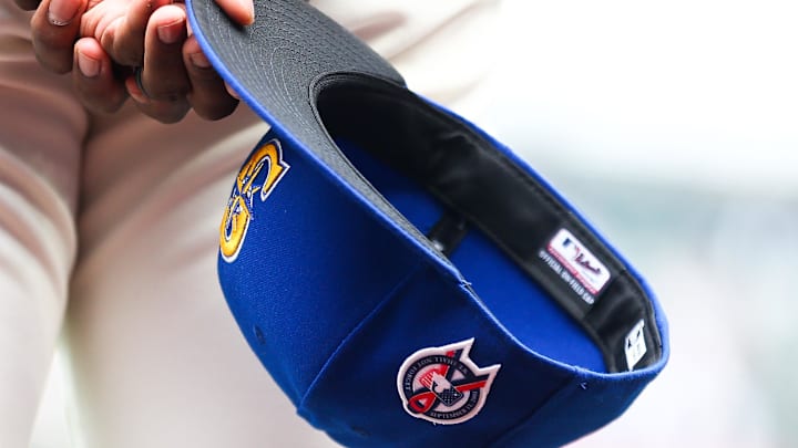 A member of the Seattle Mariners holds a baseball hat with a patch honoring the victims of the September 11th terrorist attacks before the game against the Atlanta Braves at T-Mobile Park in 2022.