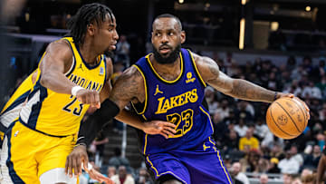Mar 29, 2024; Indianapolis, Indiana, USA; Los Angeles Lakers forward LeBron James (23) dribbles the ball while Indiana Pacers forward Aaron Nesmith (23) defends in the second half at Gainbridge Fieldhouse. Mandatory Credit: Trevor Ruszkowski-Imagn Images