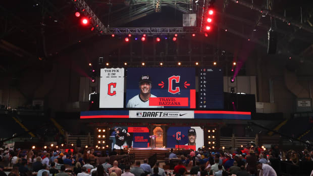 A crowd of people in front of a stage, which has a red, white, and blue banner behind it.