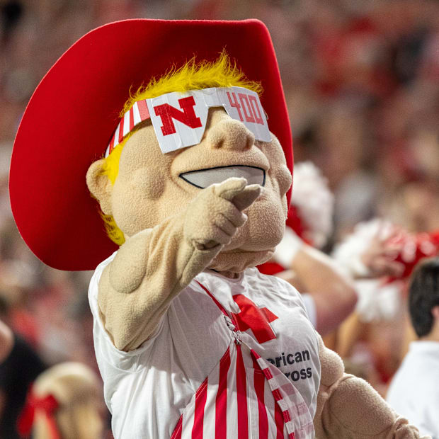 Herbie Husker pumps up the crowd while showing off his special 400th commemorative glasses.