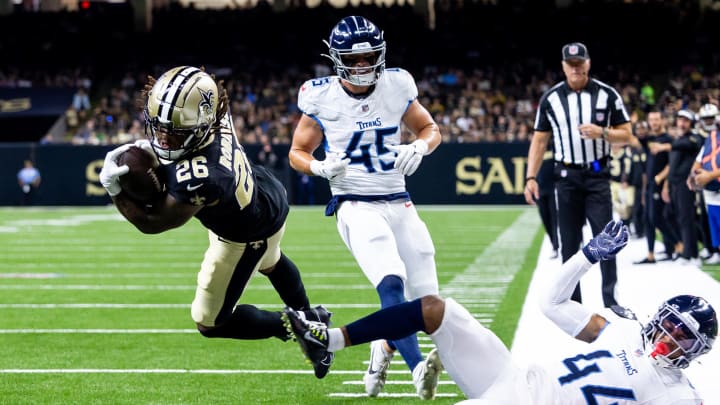 Aug 25, 2024; New Orleans, Louisiana, USA;  New Orleans Saints running back James Robinson (26) dives in for a touchdown over Tennessee Titans safety Mike Brown (44) and linebacker Chance Campbell (45) but the play is called back for offensive holding during the first half at Caesars Superdome. Mandatory Credit: Stephen Lew-USA TODAY Sports