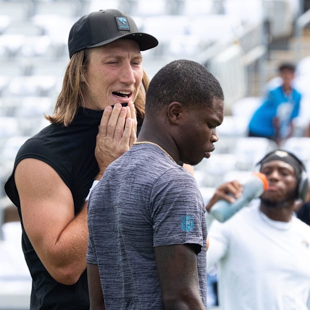 Jacksonville Jaguars quarterback Trevor Lawrence (16) talks with Jacksonville Jaguars wide receiver Travis Hunter (12) before