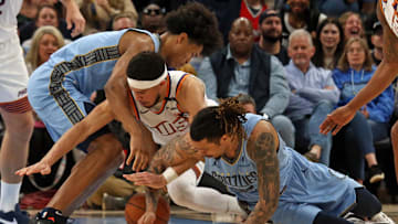 Feb 25, 2025; Memphis, Tennessee, USA; Memphis Grizzlies forward Jaylen Wells (left), forward Brandon Clarke (right) and Phoenix Suns guard Devin Booker (middle) battle for a loose ball during the fourth quarter at FedExForum. Mandatory Credit: Petre Thomas-Imagn Images