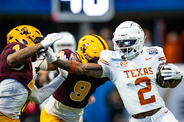 Texas Longhorns wide receiver Matthew Golden grabs the facemask of Arizona State Sun Devils defensive back Myles Rowser.