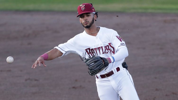 Wisconsin Timber Rattlers' Eric Brown Jr. (20) throws a runner out at first base against the Peoria