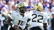 Sep 27, 2025; Manhattan, Kansas, USA; UCF Knights quarterback Jacurri Brown (11) fakes a handoff to running back Myles Montgomery (22) during the second quarter at Bill Snyder Family Football Stadium. Mandatory Credit: Scott Sewell-Imagn Images