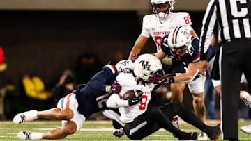 Nov 15, 2024; Tucson, Arizona, USA; Arizona Wildcats defensive back Genesis Smith (12) tackles Houston Cougars wide receiver Devan Williams (8) during the second quarter at Arizona Stadium. Mandatory Credit: Aryanna Frank-Imagn Images