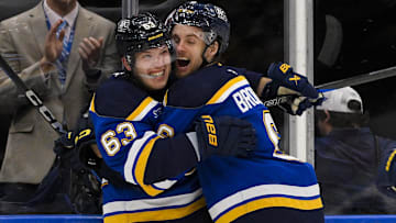 Oct 17, 2024; St. Louis, Missouri, USA;  St. Louis Blues left wing Jake Neighbours (63) celebrates with defenseman Philip Broberg (6) after scoring the game winning goal against New York Islanders goaltender Ilya Sorokin (not pictured) in overtime at Enterprise Center. Mandatory Credit: Jeff Curry-Imagn Images