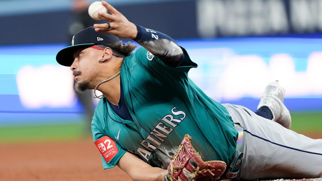 Oct 13, 2025; Toronto, Ontario, CAN; Seattle Mariners infielder Josh Naylor (12) throws the ball to first for an out during the fifth inning against the Toronto Blue Jays during game two of the ALCS round for the 2025 MLB playoffs at Rogers Centre. Mandatory Credit: Nick Turchiaro-Imagn Images