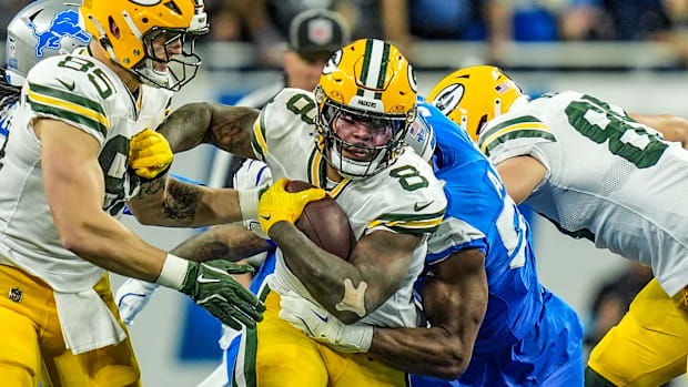 Green Bay Packers running back Josh Jacobs (8) breaks through the line before being tackled