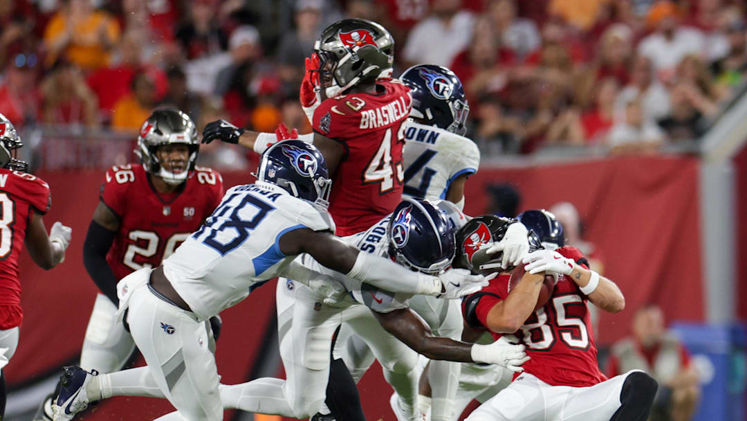 Aug 9, 2025; Tampa, Florida, USA; Tennessee Titans linebacker Curtis Jacobs (57) grabs the helmet of Tampa Bay Buccaneers wide receiver Garrett Greene (85) in the second quarter during a preseason game at Raymond James Stadium. Mandatory Credit: Nathan Ray Seebeck-Imagn Images