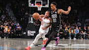 Jan 21, 2025; Brooklyn, New York, USA;  New York Knicks guard Jalen Brunson (11) looks to make a pass while driving past Brooklyn Nets center Nic Claxton (33) in the first quarter at Barclays Center. Mandatory Credit: Wendell Cruz-Imagn Images