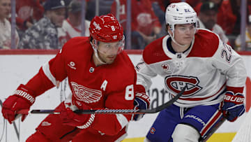 Apr 15, 2024; Detroit, Michigan, USA;  Detroit Red Wings defenseman Ben Chiarot (8) skates while chased by Montreal Canadiens right wing Cole Caufield (22) in the second period at Little Caesars Arena. Mandatory Credit: Rick Osentoski-Imagn Images