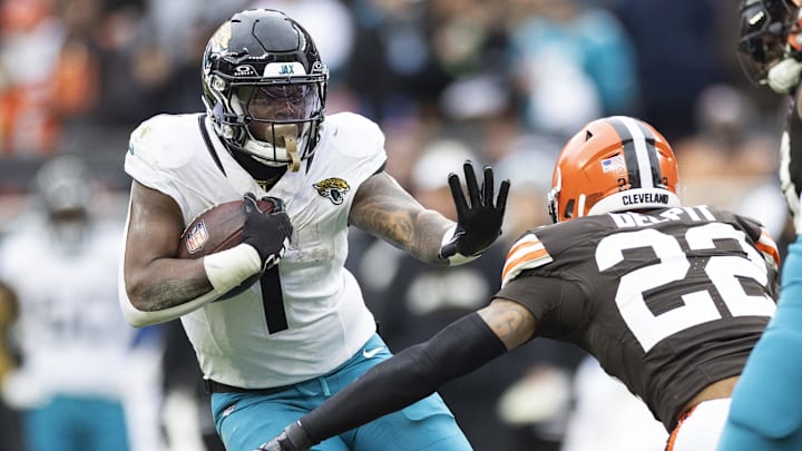Dec 10, 2023; Cleveland, Ohio, USA; Jacksonville Jaguars running back Travis Etienne Jr. (1) pushes Cleveland Browns safety Grant Delpit (22) at Cleveland Browns Stadium. Mandatory Credit: Scott Galvin-USA TODAY Sports