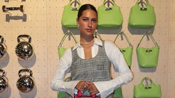 Reneé Noe posed in front of a rack of weights, dumbells and handbags, playing into the theme of the intersection of sports and fashion.