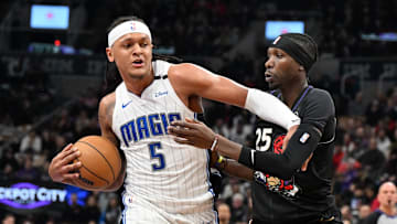 Jan 21, 2025; Toronto, Ontario, CAN;  Orlando Magic forward Paolo Banchero (5) pushes off Toronto Raptors forward Chris Boucher (25) in the first half at Scotiabank Arena. Mandatory Credit: Dan Hamilton-Imagn Images