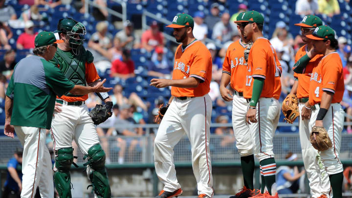 Jun 20, 2016; Omaha, NE, USA; Miami Hurricanes pitcher Danny Garcia (14) hands the ball to head coach Jim Morris (3) in the sixth inning against the UC Santa Barbara Gauchos in the 2016 College World Series at TD Ameritrade Park. UC Santa Barbara defeated Miami 5-3. Mandatory Credit: Steven Branscombe-USA TODAY Sports