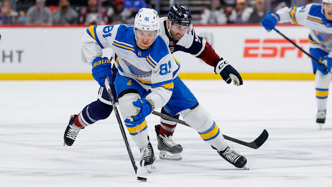Apr 5, 2026; Denver, Colorado, USA; St. Louis Blues left wing Dylan Holloway (81) controls the puck ahead of Colorado Avalanche center Nazem Kadri (91) in the first period at Ball Arena. Mandatory Credit: Isaiah J. Downing-Imagn Images