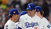 Los Angeles Dodgers pitcher Roki Sasaki (11) talks with pitcher Yoshinobu Yamamoto (left) before the game against the Hanshin Tigers at Tokyo Dome on March 16.