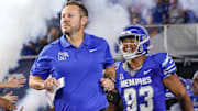 Memphis coach Ryan Silverfield and defensive lineman Jalen Bell run onto the field before the game against the Tulsa Golden Hurricane at Simmons Bank Liberty Stadium. 
