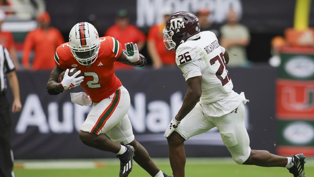 Sep 9, 2023; Miami Gardens, Florida, USA; Miami Hurricanes running back Donald Chaney Jr. (2) runs with the football against Texas A&M Aggies defensive back Demani Richardson (26) during the second quarter at Hard Rock Stadium. Mandatory Credit: Sam Navarro-Imagn Images