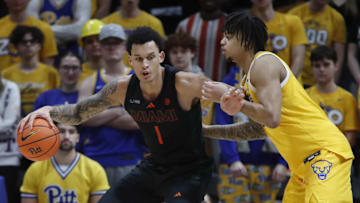 Feb 15, 2025; Pittsburgh, Pennsylvania, USA; Miami (Fl) Hurricanes center Lynn Kidd (1) handles the ball against Pittsburgh Panthers forward Cameron Corhen (2) during the second half at the Petersen Events Center. Mandatory Credit: Charles LeClaire-Imagn Images