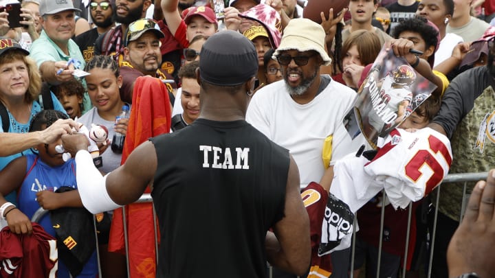 Jul 27, 2023; Ashburn, VA, USA; Washington Commanders wide receiver Terry McLaurin (M) signs autographs for fans after morning practice during day two of Commanders training camp at OrthoVirginia Training Center. Mandatory Credit: Geoff Burke-USA TODAY Sports