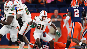 Nov 30, 2024; Syracuse, New York, USA; Syracuse Orange defensive back Justin Barron (8) tackles Miami Hurricanes running back Jordan Lyle (21) during the first half at the JMA Wireless Dome.